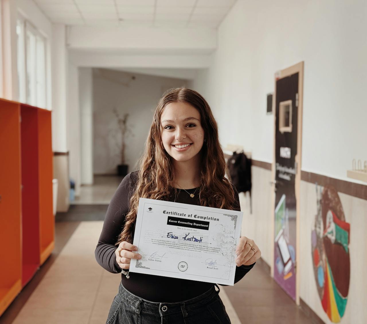 young-woman-holding-certificate-in-school-hallway-32590743